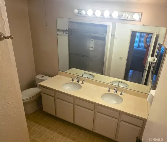 a bathroom with a sink double vanity granite and a mirror