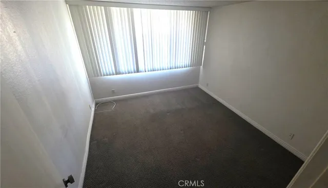 a view of a small space with wooden floor and a window