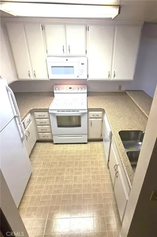 a kitchen with a stove and white cabinets