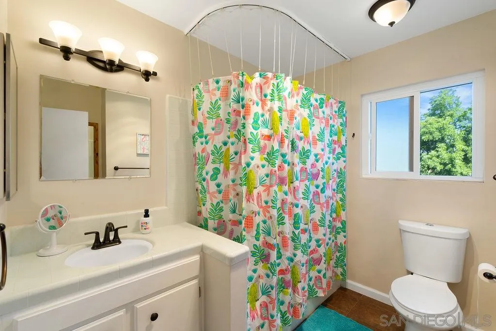 14134 Lyons Valley Road Jamul, CA 91935 - Photo 11 of 25 a bathroom with a sink a toilet and a shower curtain