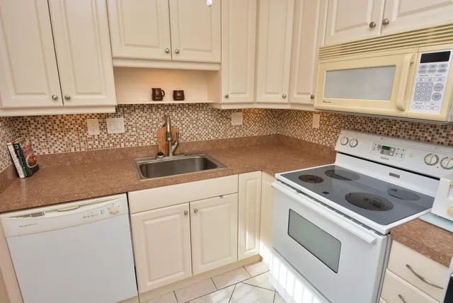 a kitchen with white cabinets and white appliances