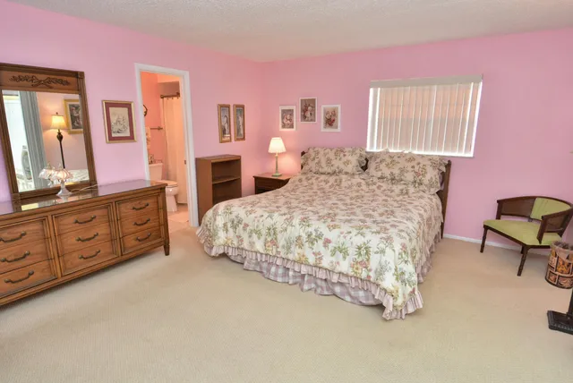 a bedroom with a bed a dresser and next to a window