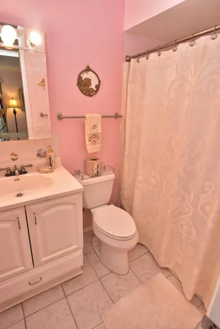a bathroom with a toilet sink vanity and mirror