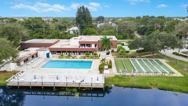 a view of a swimming pool with a yard and large tree