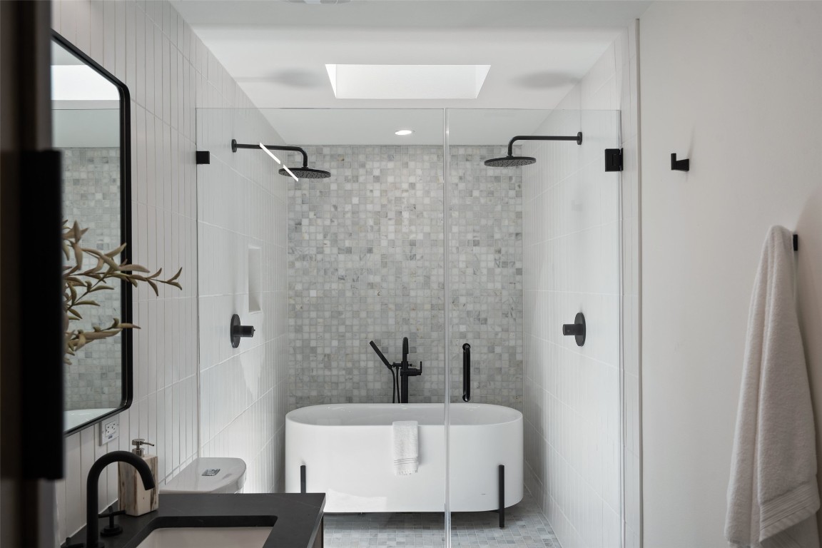 3403 Cascadera Drive Austin, TX 78731 - Photo 27 of 38 a bathroom with a sink a mirror and a bathtub