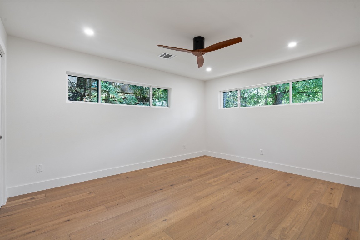 3403 Cascadera Drive Austin, TX 78731 - Photo 29 of 38 an empty room with wooden floor and ceiling fan