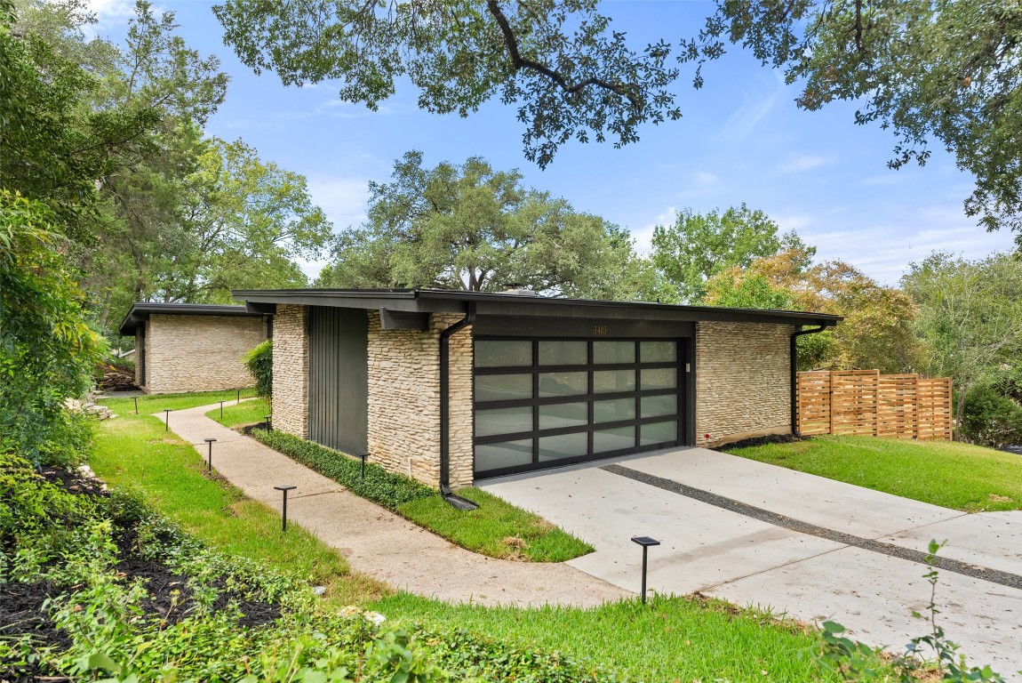 3403 Cascadera Drive Austin, TX 78731 - Photo 4 of 38 a front view of a house with a yard and garage