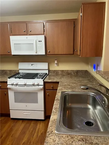 a kitchen with granite countertop a sink and a stove top oven