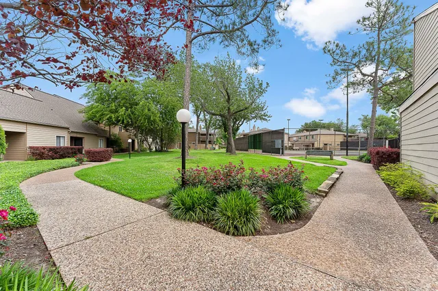 a front view of a house with a yard and fountain in middle