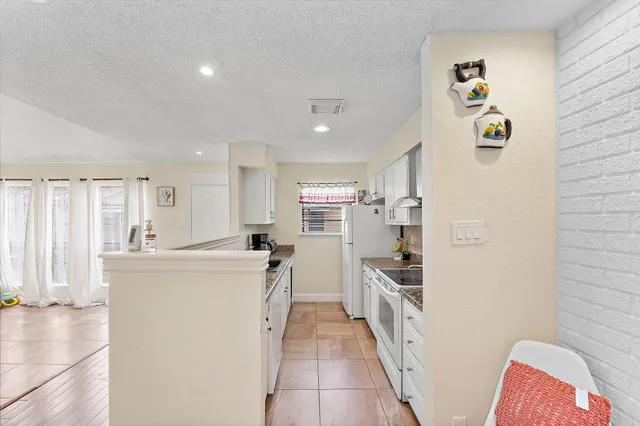 a kitchen with stainless steel appliances granite countertop a refrigerator and a stove