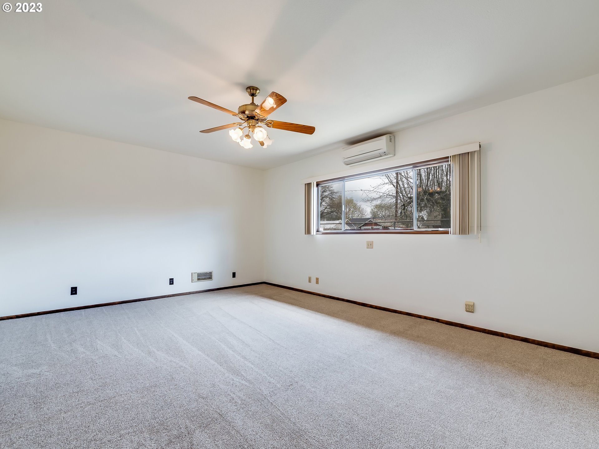 176 West C Street Springfield, OR 97477 - Photo 19 of 42 an empty room with windows and a chandelier fan