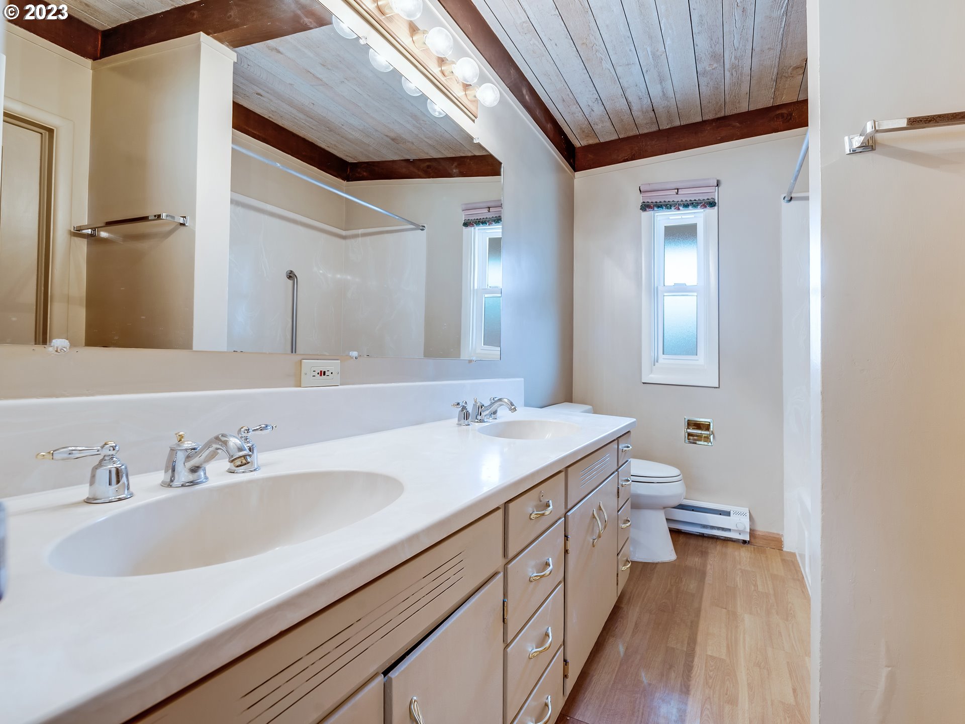 176 West C Street Springfield, OR 97477 - Photo 28 of 42 a spacious bathroom with a double vanity sink a mirror and a toilet