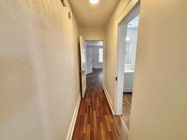 420 West Lynn Street Slaton, TX 79364 - Photo 18 of 25 a view of a hallway with wooden floor and a bathroom
