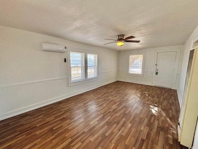 420 West Lynn Street Slaton, TX 79364 - Photo 5 of 25 an empty room with wooden floor and windows