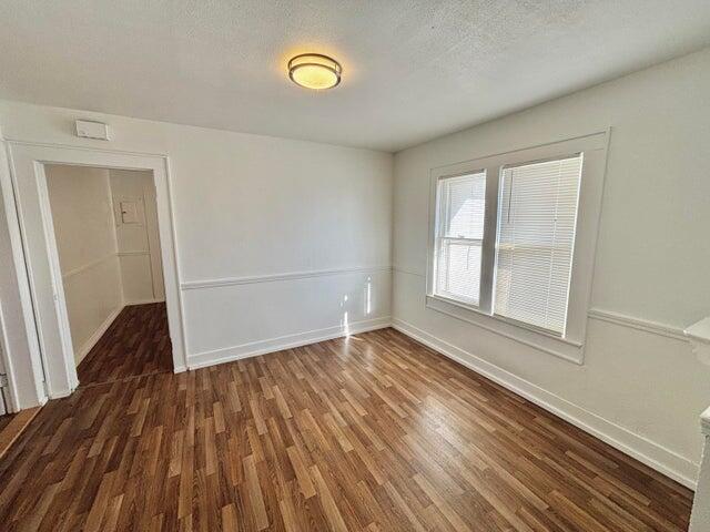 420 West Lynn Street Slaton, TX 79364 - Photo 6 of 25 an empty room with wooden floor and windows