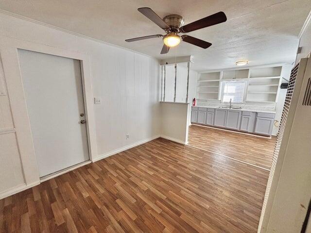 420 West Lynn Street Slaton, TX 79364 - Photo 9 of 25 a view of empty room with wooden floor and fan