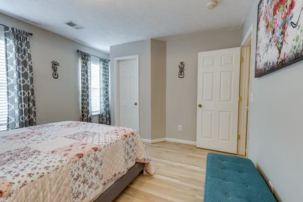 a bedroom with a bed and a painting on the wall