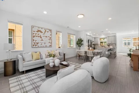 a living room with furniture kitchen view and a large window