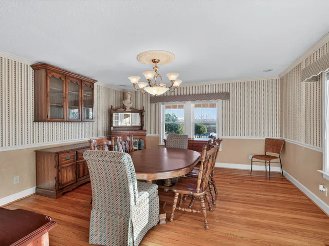 a living room with furniture chandelier and a large window