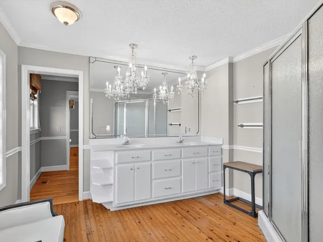 an empty room with wooden floor and fan