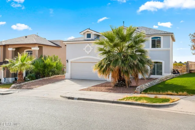 a view of a house with a yard and potted plants