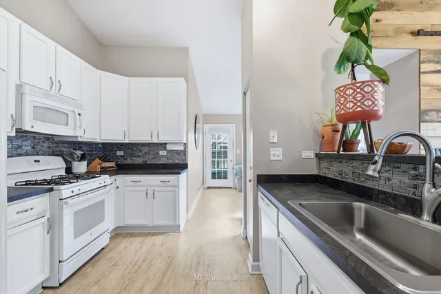 a kitchen with stainless steel appliances a sink a stove top oven a counter space and cabinets