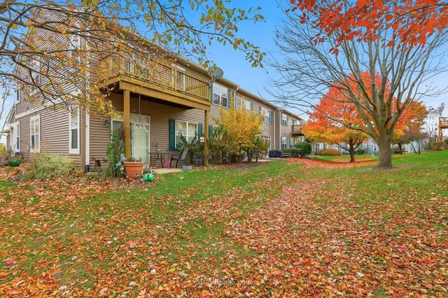 a view of a house with backyard and tree