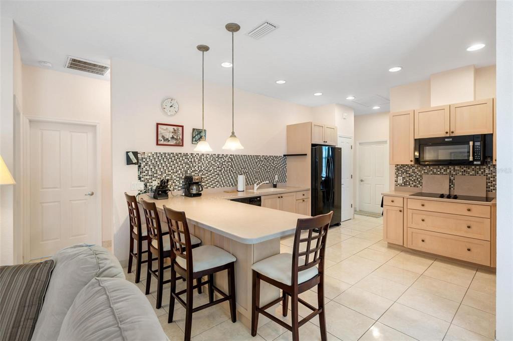 8069 Southwest Aviary Road Arcadia, FL 34269 - Photo 14 of 60 a kitchen with stainless steel appliances kitchen island granite countertop a table chairs and a refrigerator