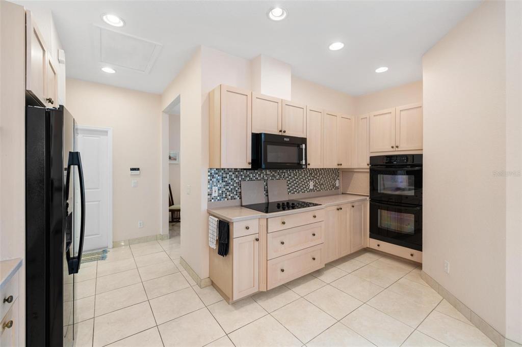 8069 Southwest Aviary Road Arcadia, FL 34269 - Photo 16 of 60 a kitchen with granite countertop a refrigerator and a stove top oven