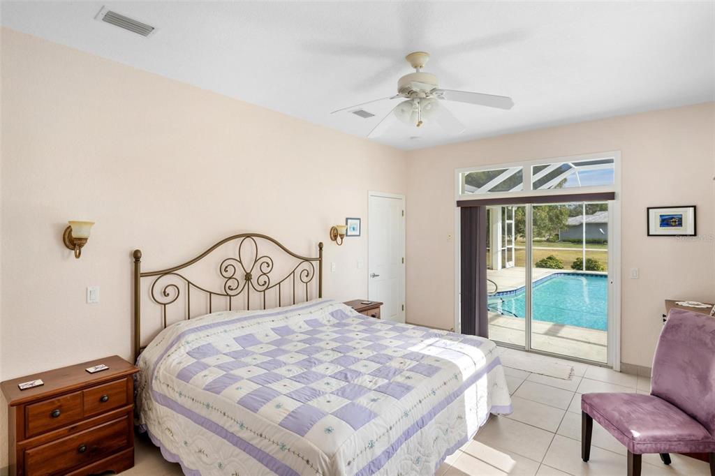 8069 Southwest Aviary Road Arcadia, FL 34269 - Photo 33 of 60 a bedroom with a bed a chandelier and a dresser