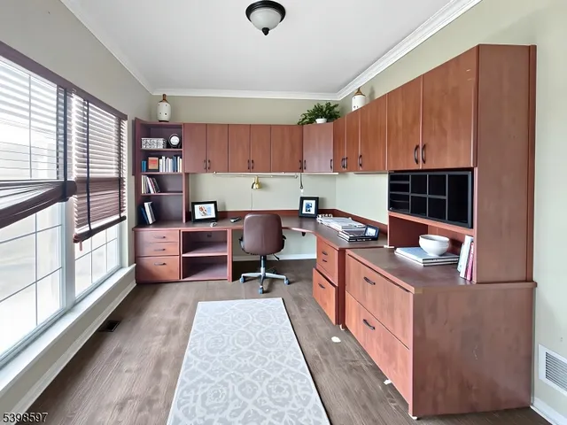 a work place with a large window and a rug