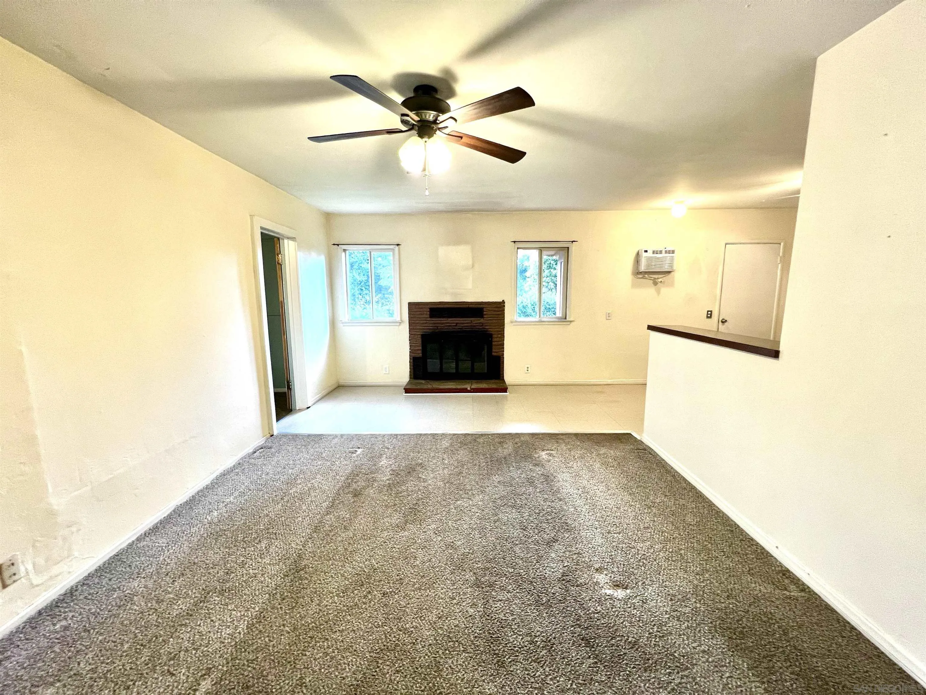 32500 Rincon Ranch Road Pauma Valley, CA 92061 - Photo 5 of 19 a view of a livingroom with a fireplace a ceiling fan and wooden floor