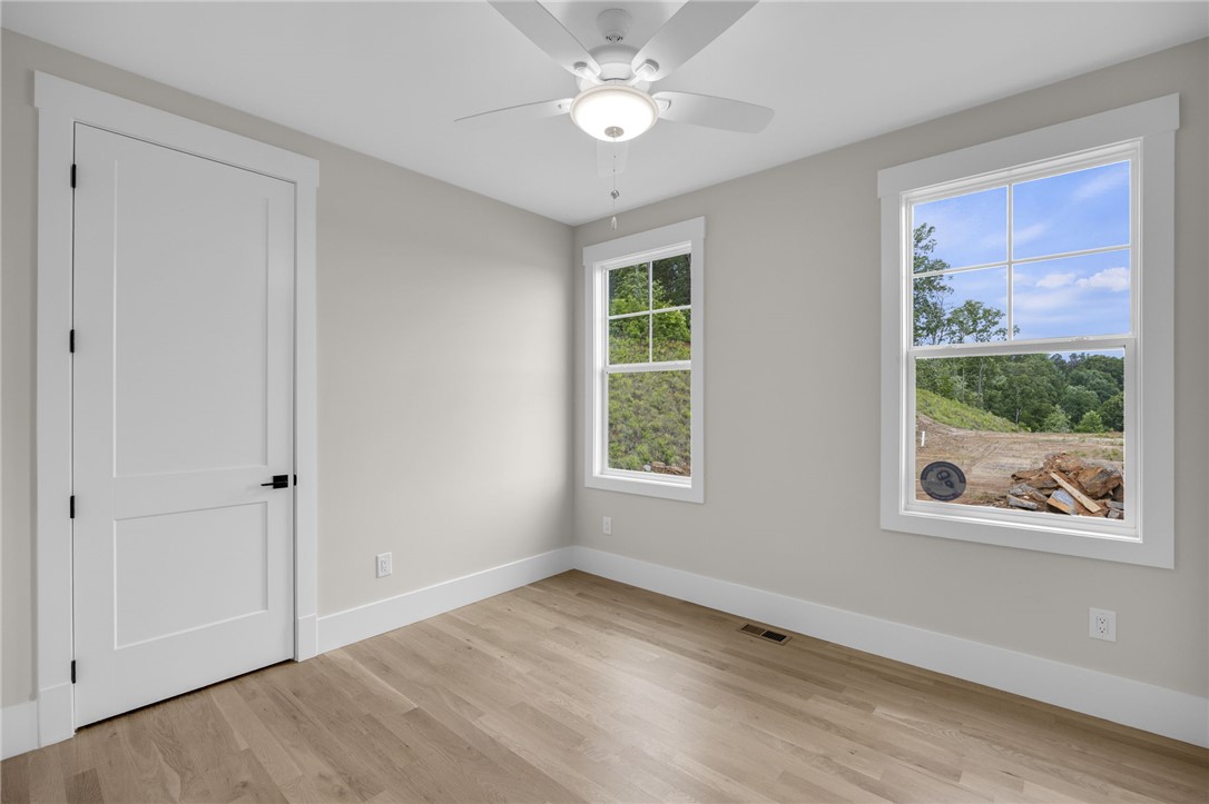 1230 Melton Road, Unit 216 West Union, SC 29696 - Photo 20 of 49 A quiet bedroom with abundant natural light features durable hardwood flooring and a functional ceiling fan.