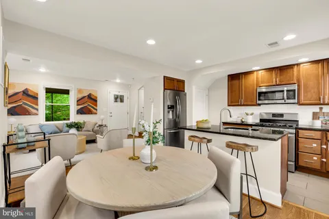 a large kitchen with stainless steel appliances granite countertop a stove a sink a dining table and chairs