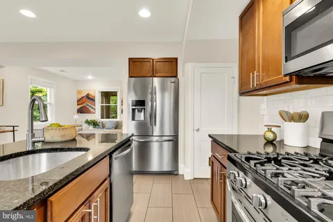 a kitchen with stainless steel appliances granite countertop a sink stove and refrigerator