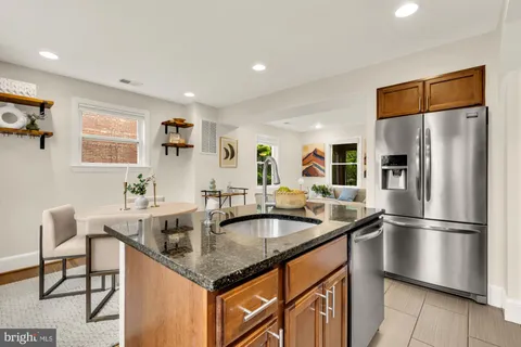 a kitchen with stainless steel appliances granite countertop a sink a refrigerator and a refrigerator