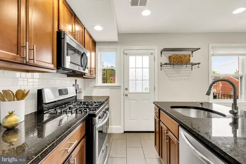 a kitchen with stainless steel appliances granite countertop a sink stove and cabinets