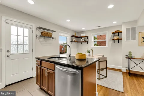 a kitchen with stainless steel appliances granite countertop a sink and a refrigerator