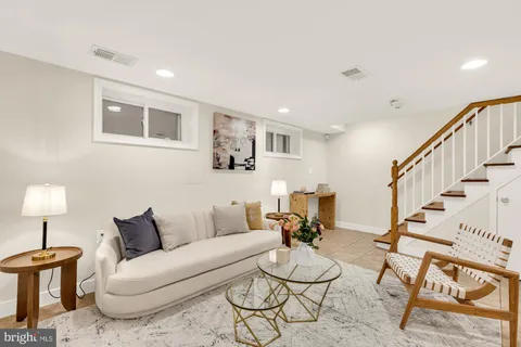 a living room with furniture a rug and a lamp
