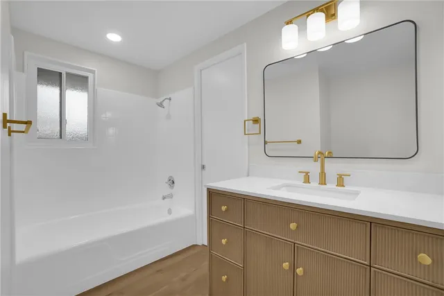 a bathroom with a tub sink and mirror