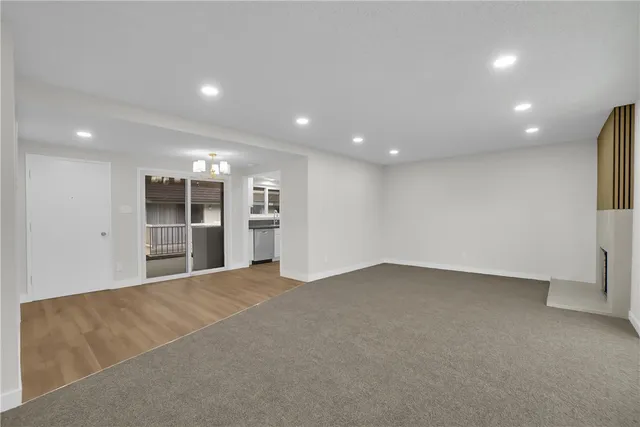 a view of an empty room with a cabinet and a kitchen