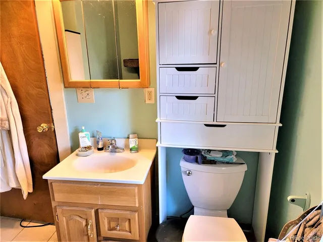 a bathroom with a toilet sink and mirror
