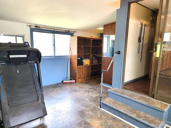 a view of a hallway with furniture and a window