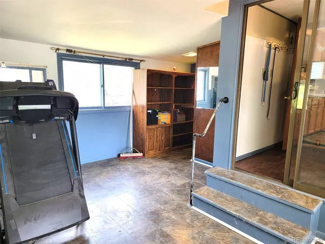 a view of a hallway with furniture and a window