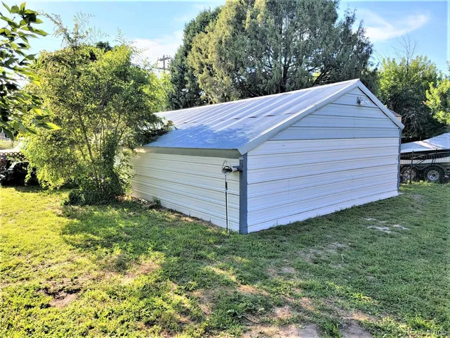 a view of a backyard with barn and large trees