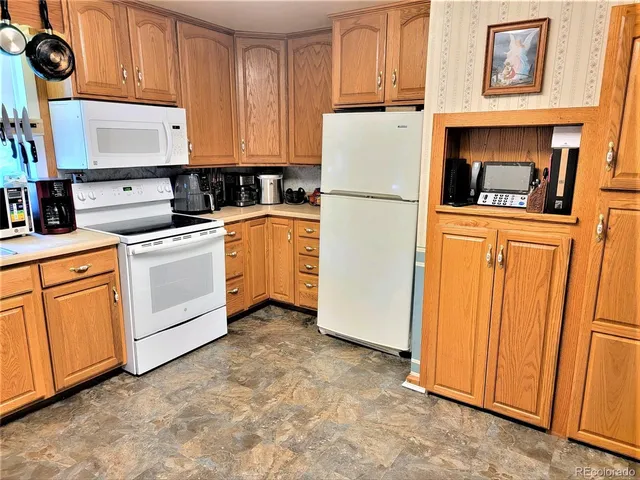 a kitchen with white cabinets and white appliances