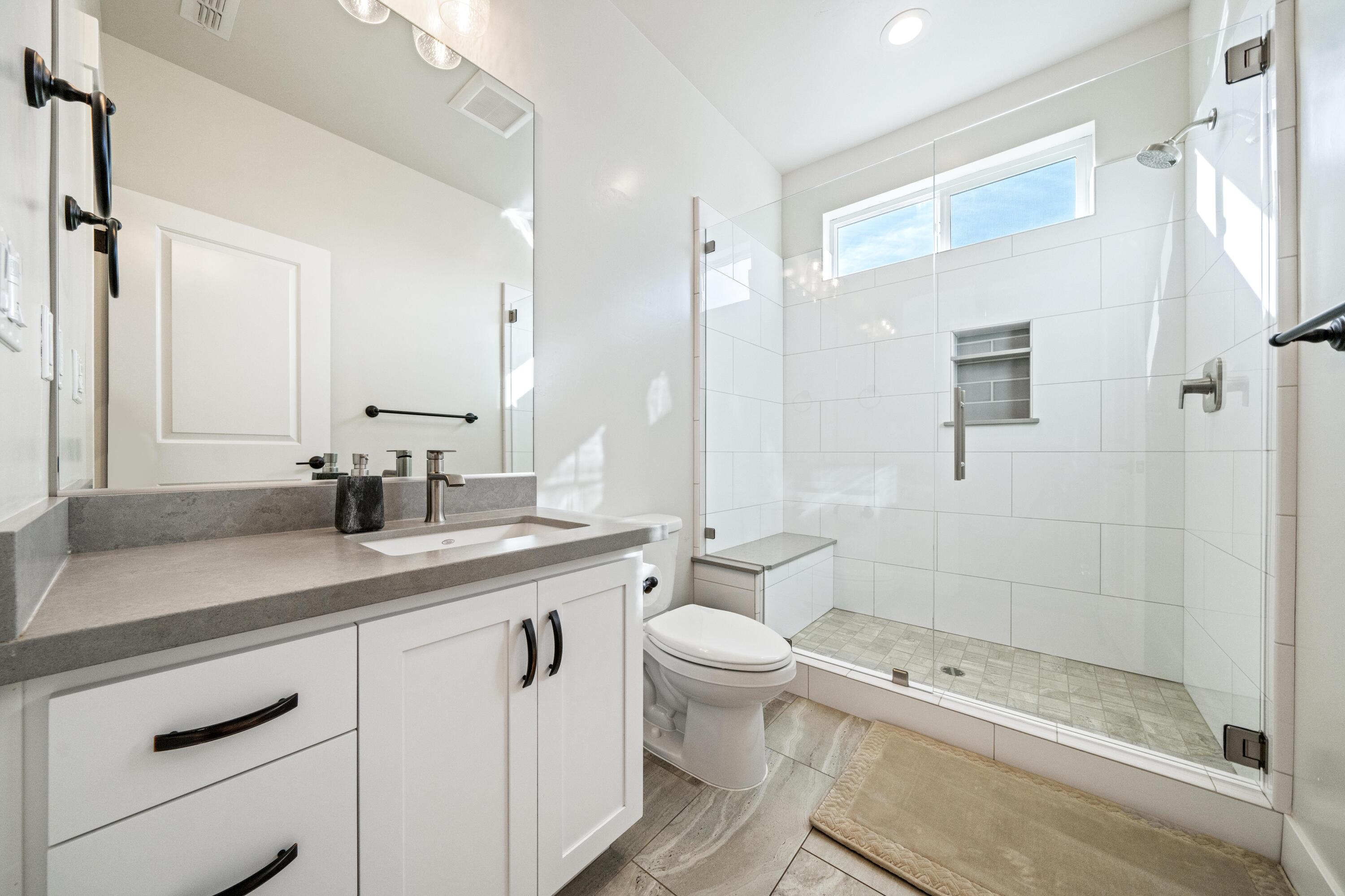 3001 Luke Trail Redding, CA 96002 - Photo 21 of 43 a bathroom with a granite countertop sink a toilet a mirror and shower