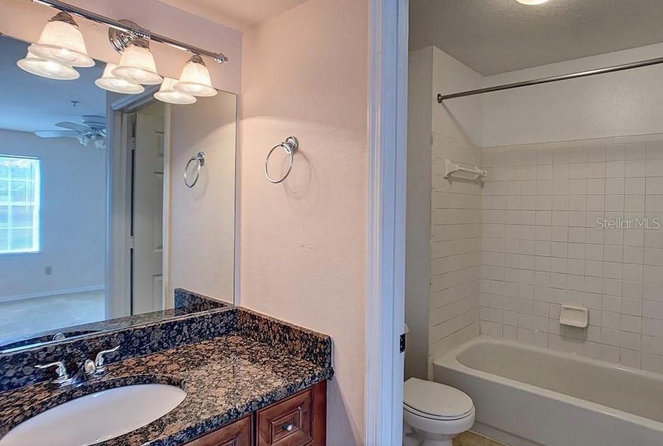 7320 Westpointe Boulevard, Unit 526 Orlando, FL 32835 - Photo 11 of 20 a bathroom with a granite countertop sink toilet and shower