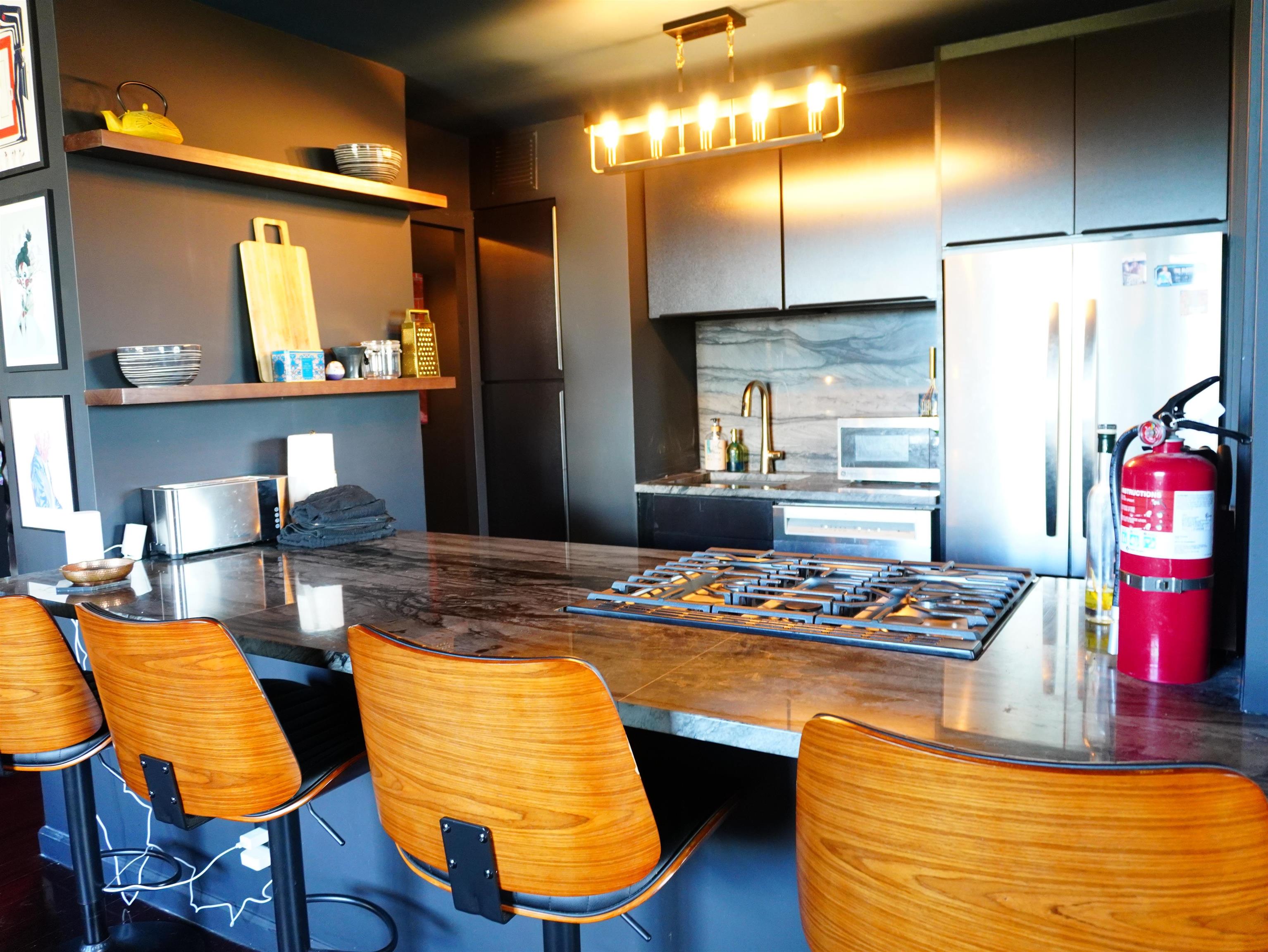 6040 Boulevard East, Unit 6B West New York, NJ 07093 - Photo 14 of 32 a kitchen with stainless steel appliances kitchen island granite countertop a stove and white cabinets