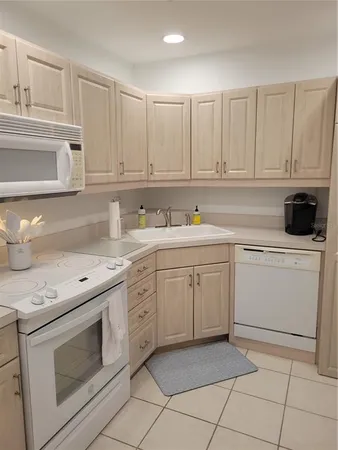 a kitchen with white cabinets and white appliances